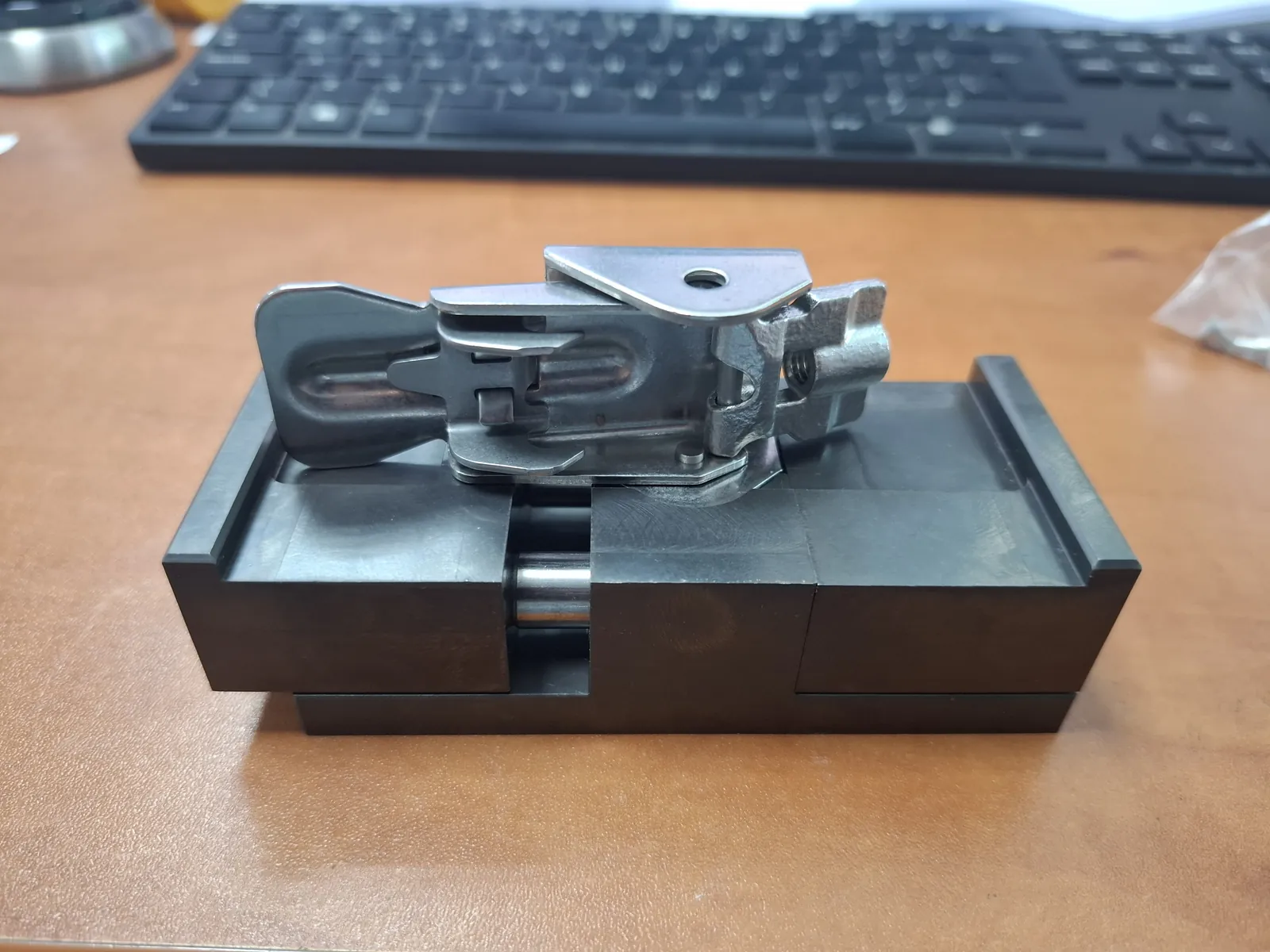 Metalowy element zaciskowy na czarnej podstawie z prowadzeniem
